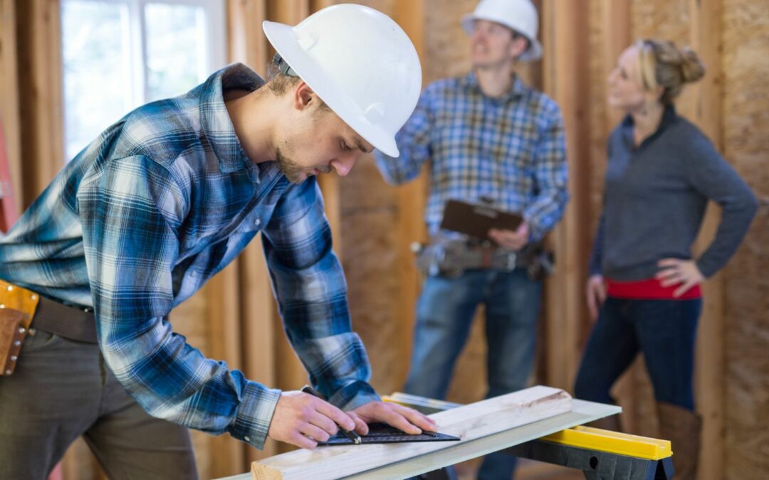 A reliable remodeling contractor saws wood for a home structure.